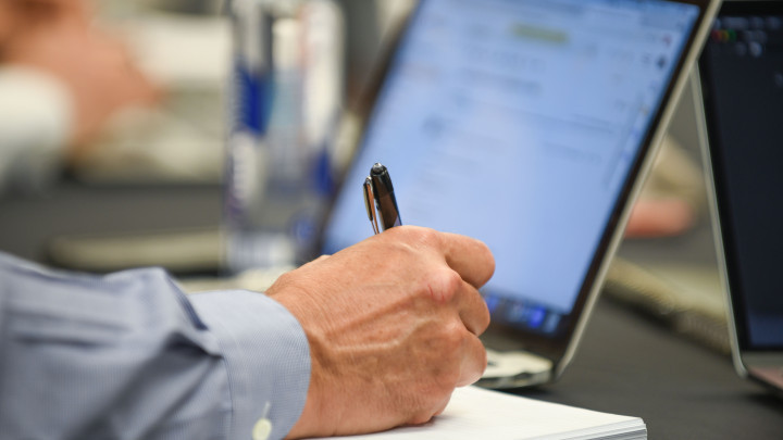 person writing while looking at screen