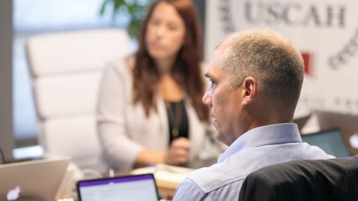 person at laptop looking at meeting